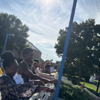 Group of students pretending to go fishing near blue bridge